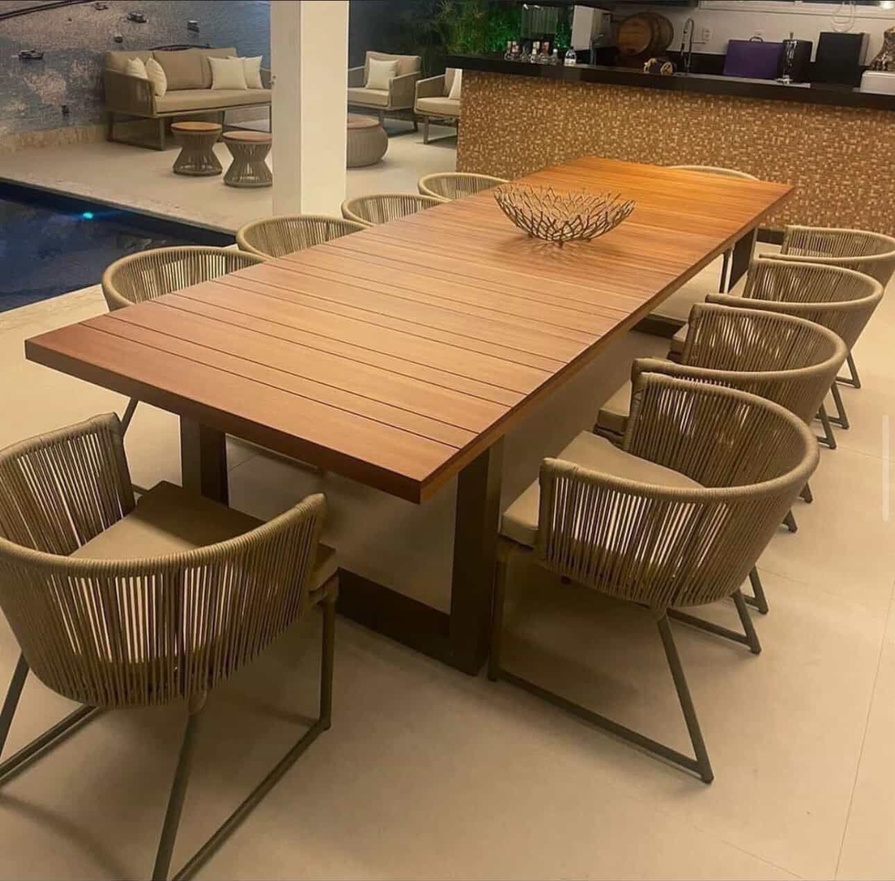 Mesa longa de jantar em ambiente externo integrado à noite